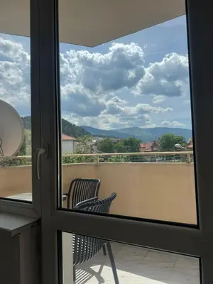 a window view of a balcony with a chair at Апартамент за гости ''ЗДРАВЕ'' in Kyustendil
