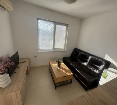 a living room with a black leather couch and a coffee table at Апартамент за гости ''ЗДРАВЕ'' in Kyustendil