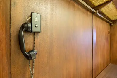a phone hanging on a wooden wall with a chain at Very Central & Aristocratic 2 Bedroom Apartment with Air conditioning in Sofia