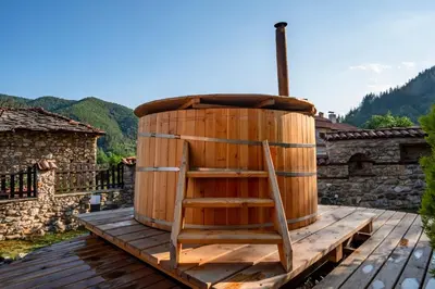 a wooden barrel with a chair sitting on a deck at Villa Martina in Smilyan