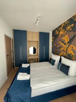 a bedroom with a large bed with a painting on the wall at Apartment Park View in Sandanski