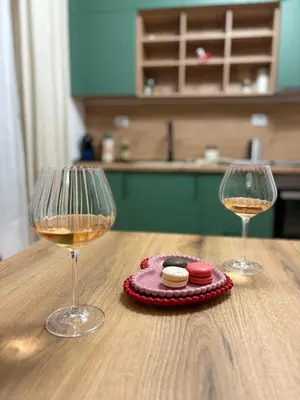 two glasses of wine sitting on a wooden table at Apartment Park View in Sandanski