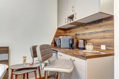a kitchen with a counter and chairs in a room at Cozy Studio in Grand Resort Pamporovo by Flat Manаger in Pamporovo