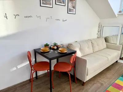 a living room with a table and a couch at Comfy Studio by Cosher in Sofia