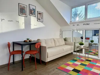 a living room with a couch and a table and chairs at Comfy Studio by Cosher in Sofia