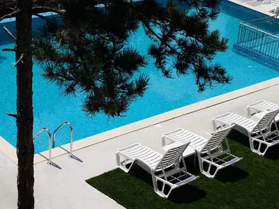 a group of lounge chairs next to a swimming pool at D Villa in Mineralni Bani