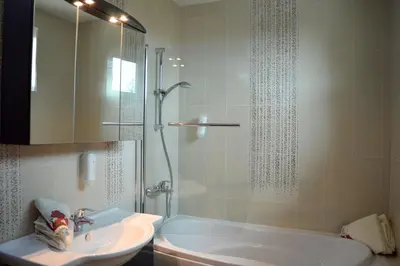a bathroom with a shower and a sink and a tub at D Villa in Mineralni Bani