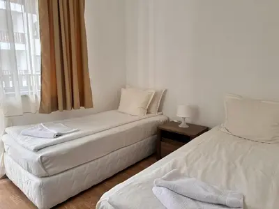 two twin beds in a room with a window at Sunny two bedroom apartment 12 in Tulip , Flora Residence - prime location! in Borovets