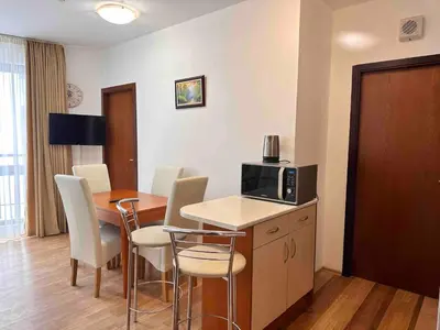 a kitchen and dining room with a table and chairs at Sunny two bedroom apartment 12 in Tulip , Flora Residence - prime location! in Borovets