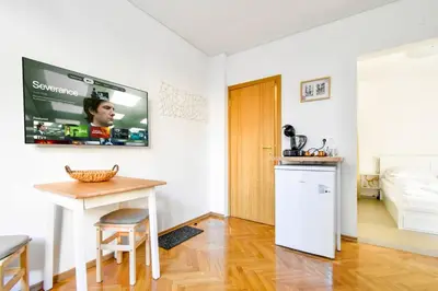 a kitchen with a table and a tv on the wall at Central Duplex Wi-Fi, Kitchen, Netflix, Heating in Sofia