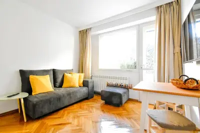 a living room with a gray couch and yellow pillows at Central Duplex Wi-Fi, Kitchen, Netflix, Heating in Sofia