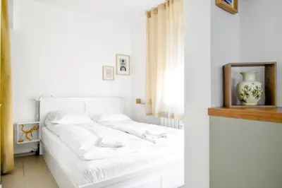 a white bed in a white bedroom with a window at Central Duplex Wi-Fi, Kitchen, Netflix, Heating in Sofia