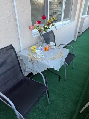 a table with a vase of flowers on a porch at Апартамент ГТ in Plovdiv