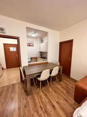 a kitchen and dining room with a wooden table and chairs at Apartment for 6 in Flora main building - prime location! in Borovets