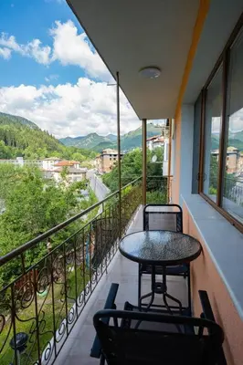 a balcony with a table and chairs and a view at Апартамент за гости Симона in Smolyan