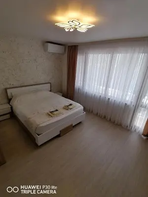 a bedroom with a bed and a chandelier at Апартамент за гости Симона in Smolyan
