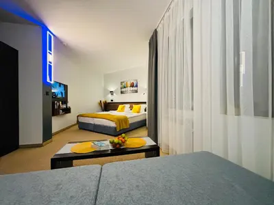 a hotel room with a bed and a living room at Passion & Sense Studios Pamporovo in Pamporovo