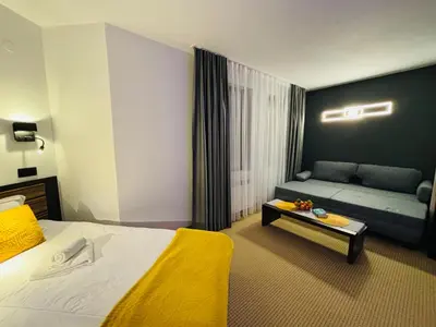 a hotel room with a bed and a couch at Passion & Sense Studios Pamporovo in Pamporovo