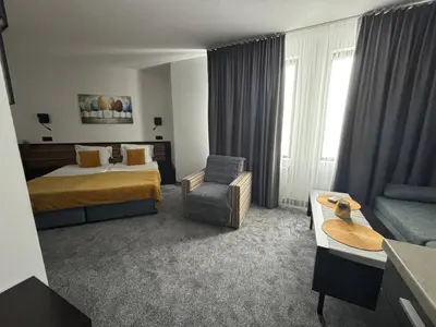 a hotel room with a bed and a chair at Passion & Sense Studios Pamporovo in Pamporovo