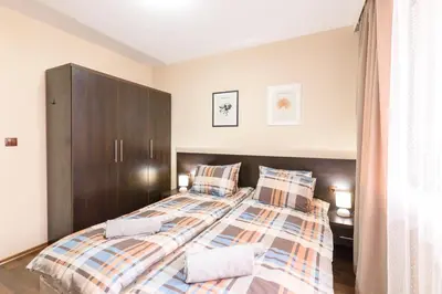 a bedroom with two beds and a brown cabinet at Liftside Alpine Suite in Bansko