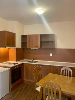 a kitchen with wooden cabinets and a wooden table with a tableablish at Mountain view 1-bedroom apartment few steps from ski piste and Gondola lift in Bansko