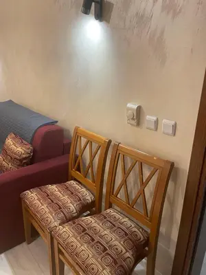 a room with two wooden chairs and a bed at English Apartments 2 in Bansko