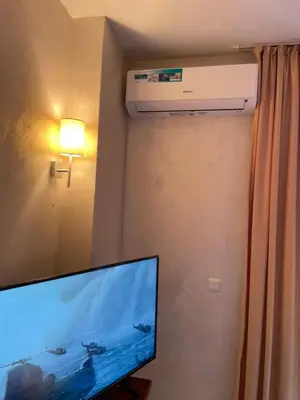 a living room with a television and a air conditioner at English Apartments 2 in Bansko