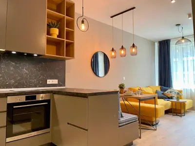 a kitchen and living room with a yellow couch at Apartment with Free Underground Parking by COSHER in Sofia