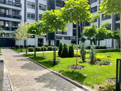 a park with trees in front of a building at Apartment with Free Underground Parking by COSHER in Sofia