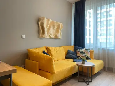 a living room with a yellow couch and a table at Apartment with Free Underground Parking by COSHER in Sofia