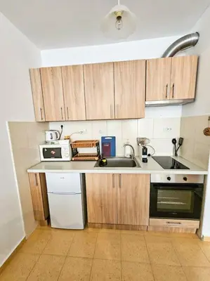 a kitchen with wooden cabinets and a sink at Mountain Dream A8 apartment in Borovets