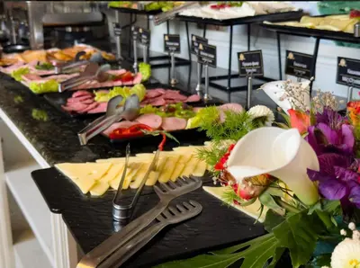 a buffet line with cheese and meats and utensils at Rich House Velingrad in Velingrad