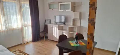 a small living room with a table and a tv at Студио Вили in Smolyan