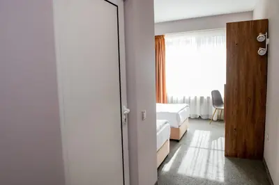 a bedroom with a mirror and a bed and a window at BG Hotel in Sofia