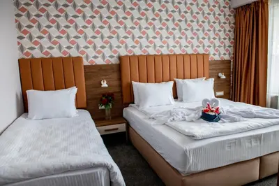 two beds in a hotel room with flowers on them at BG Hotel in Sofia