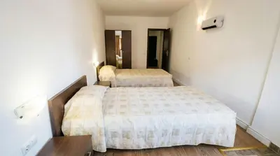 two beds in a small room with white walls at Mountain Paradise 2 - Cosy 2 Bed Mountain View Apartment - Washer in Bansko