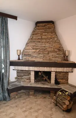 a brick fireplace with two candles on top of it at Къща за Гости БАРБЕЛ in Golyam Izvor