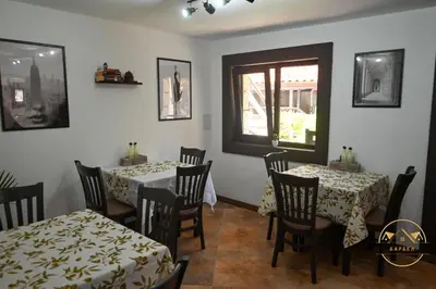 a dining room with two tables and chairs and a window at Къща за Гости БАРБЕЛ in Golyam Izvor