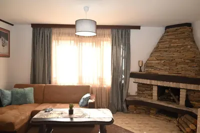 a living room with a couch and a fireplace at Къща за Гости БАРБЕЛ in Golyam Izvor
