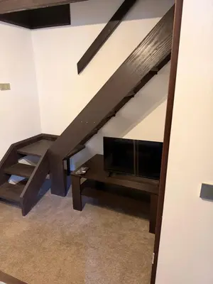 a living room with a couch and a tv and a staircase at Къща за Гости БАРБЕЛ in Golyam Izvor