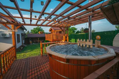 a hot tub on a deck with a pergola at Къщи за гости 'Веринско' in Verinsko