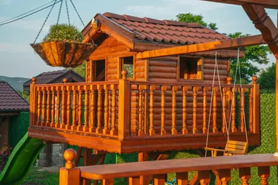 a tree house on a playground with a swing at Къщи за гости 'Веринско' in Verinsko