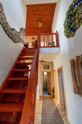 a winding staircase in a house with wooden steps at Къщи за гости 'Веринско' in Verinsko