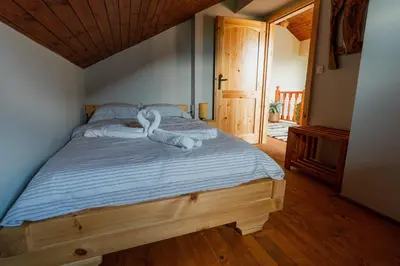 a bedroom with a bed with swans on it at Къщи за гости 'Веринско' in Verinsko