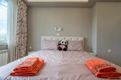 a teddy bear sitting on top of a pink bed at Green Haven in Sofia