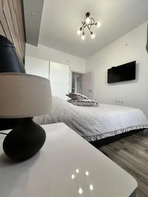 a bedroom with a bed and a table with a lamp at Royalton Résidence in Plovdiv