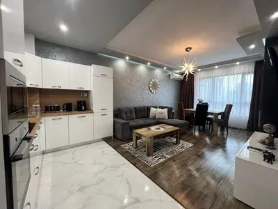 a kitchen and living room with a couch and a table at Royalton Résidence in Plovdiv