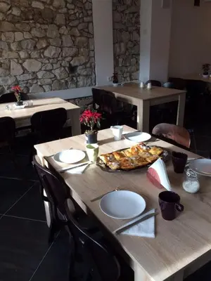 a wooden table with a pizza on top of it at Hotel Hinovi Hvoyna in Hvoyna