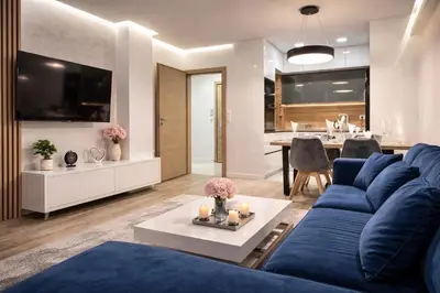a living room with a blue couch and a table at Delux 1 - Plovdiv Луксозен апартамент с паркинг in Plovdiv
