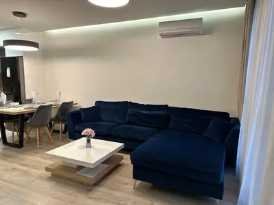 a living room with a blue couch and a table at Delux 1 - Plovdiv Луксозен апартамент с паркинг in Plovdiv